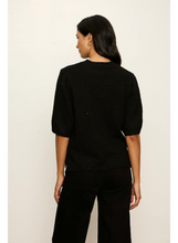 Woman wearing a black Perfect Sequin Sweater Tee by Sanctuary, shown from the back with loose fit and short sleeves.