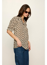 Woman wearing Sanctuary Inkblot Eden Button Blouse with short sleeves and sunglasses against plain background