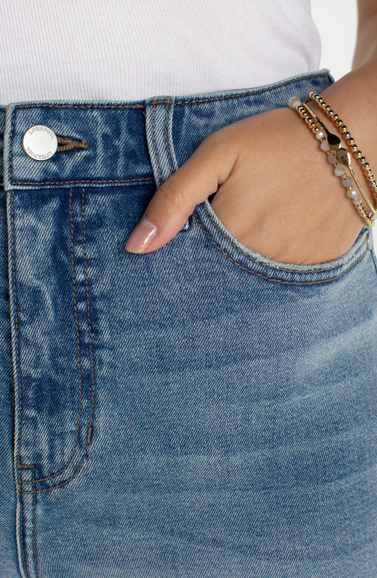 Close-up of light blue denim with hand in pocket wearing Symphony HR Liv Relaxed Crop Skinny With Wide Hem 27" Inseam by liverpool