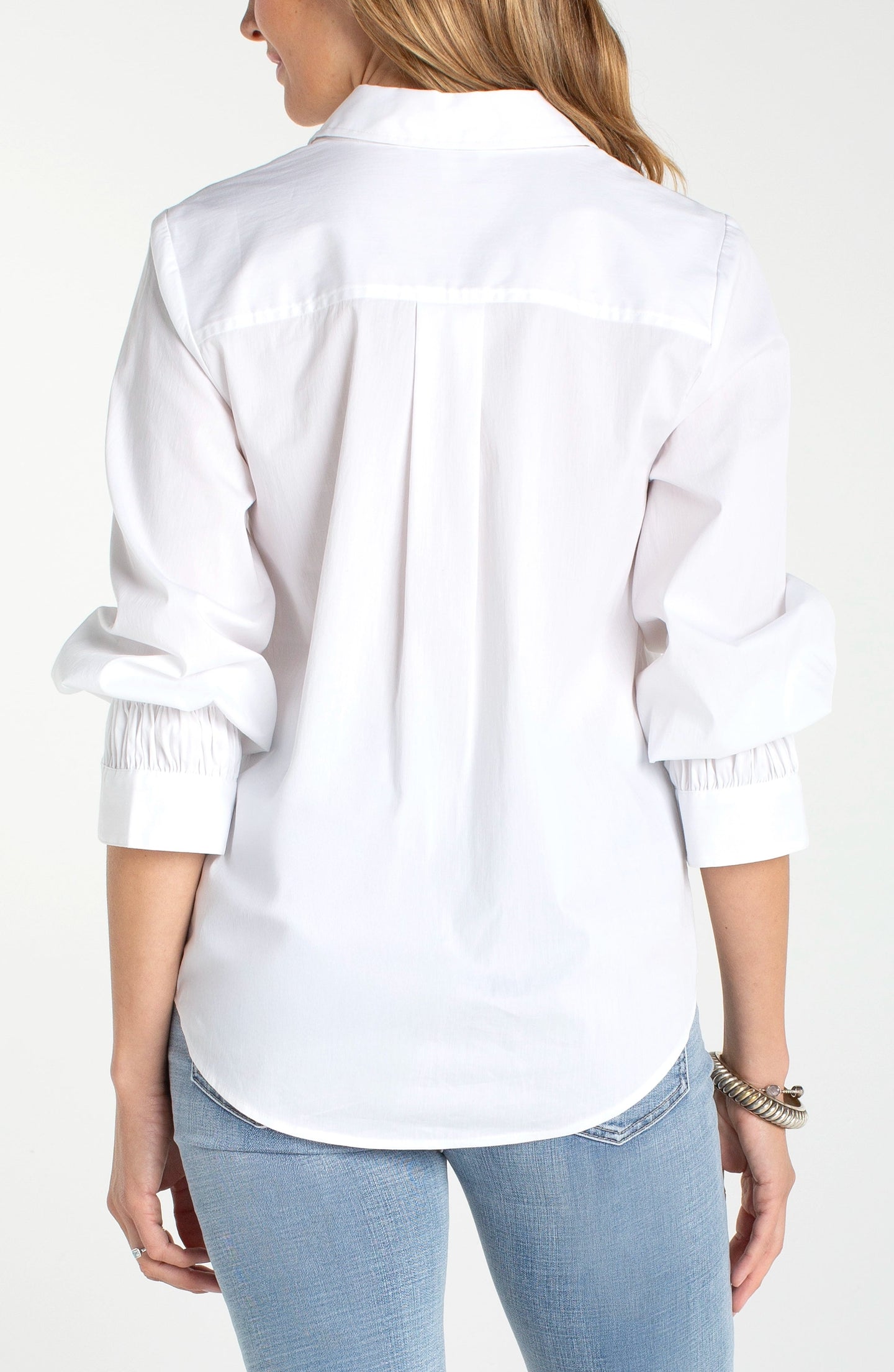 Back view of a woman wearing a White Adjustable Sleeve Button Front Woven Top by liverpool with rolled sleeves