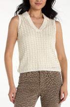 Woman wearing liverpool Cream Sleeveless Johnny Collar Sweater with patterned brown pants against white background