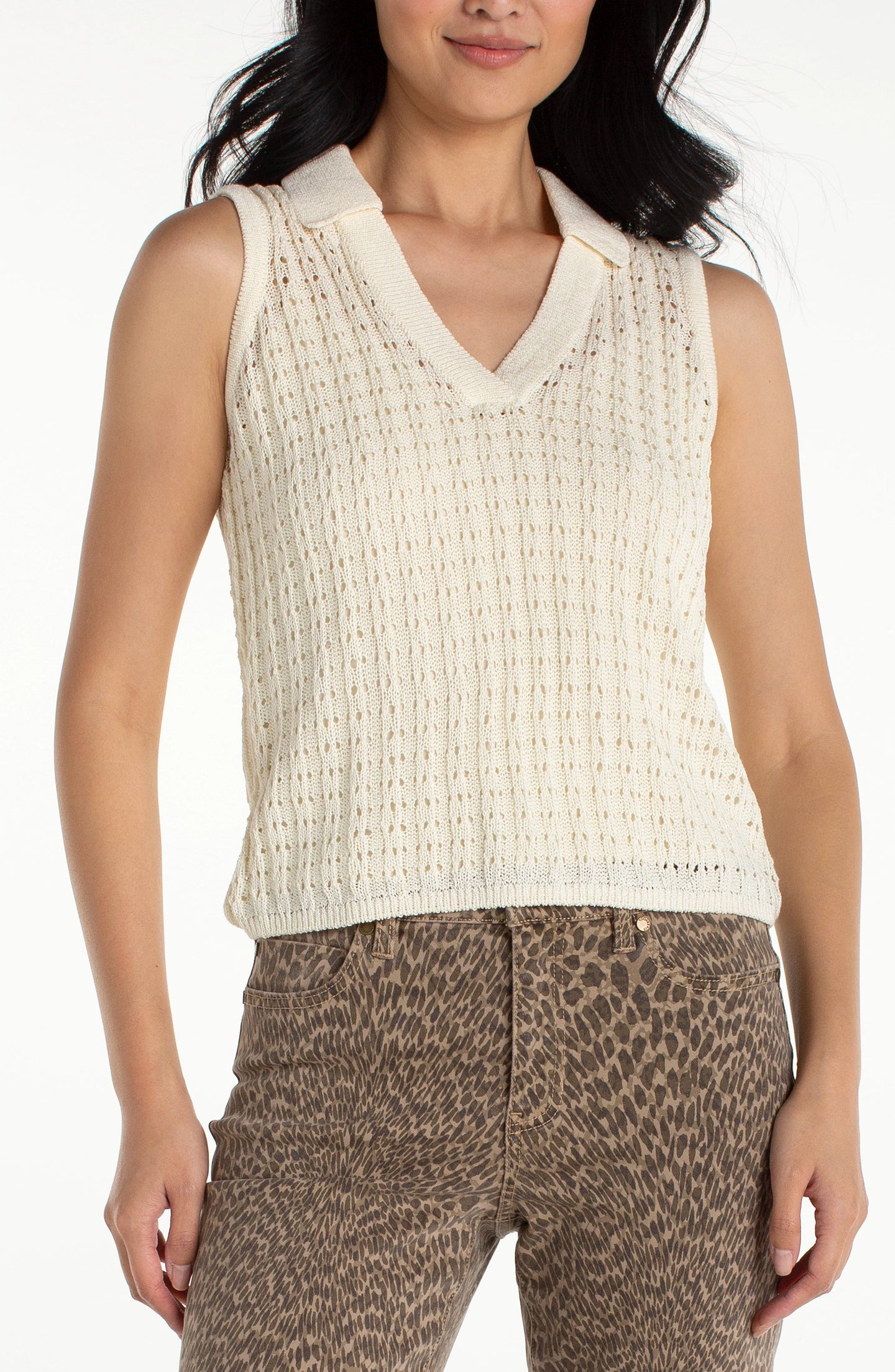 Woman wearing liverpool Cream Sleeveless Johnny Collar Sweater with patterned brown pants against white background