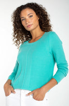 Woman wearing waterfall teal long sleeve crew neck sweater by liverpool with textured knit and white pants