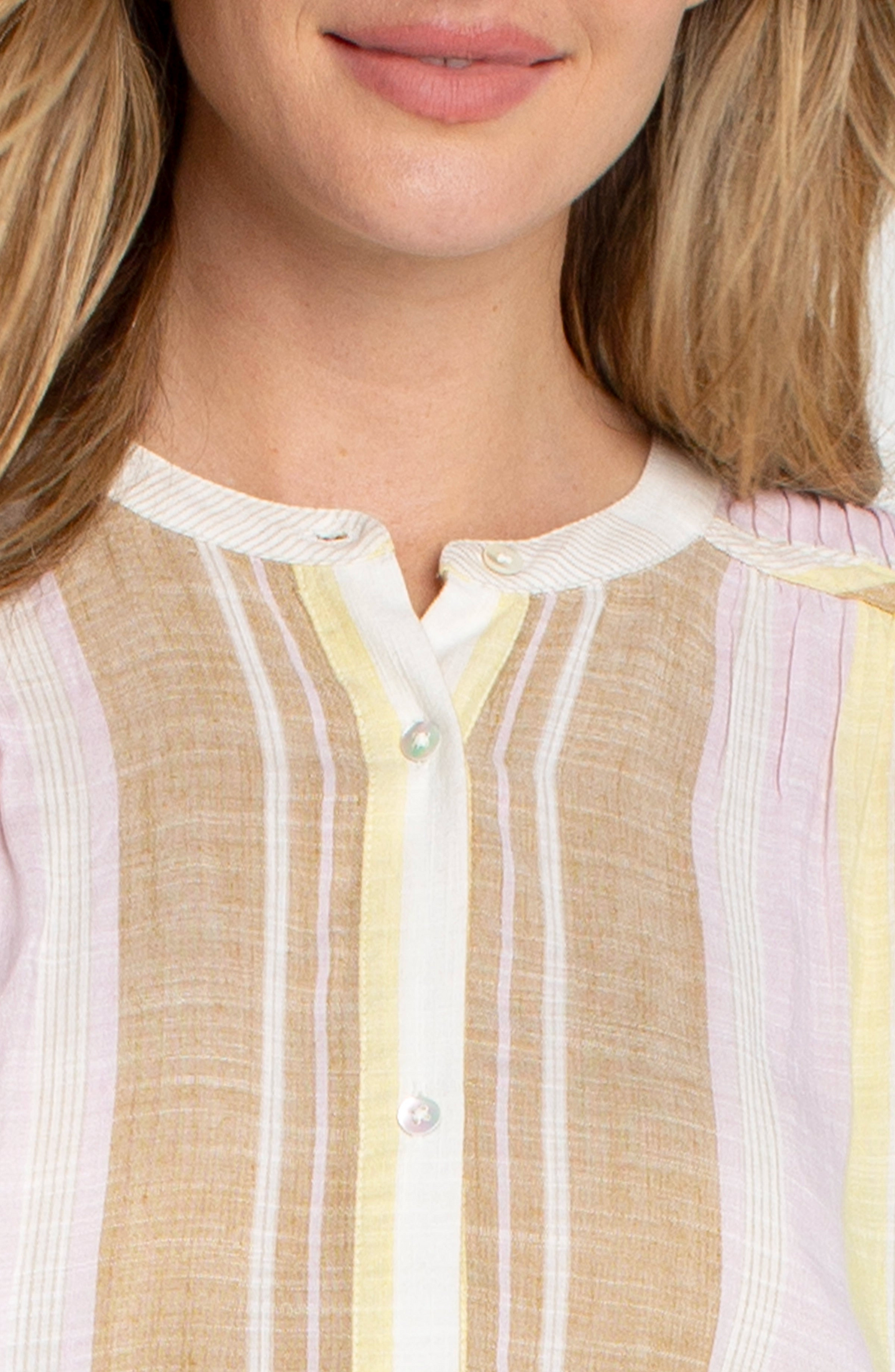 Close-up of a woman wearing a Neapolitan Dolman Button Front Woven Blouse with Shirring by liverpool in soft pastel stripes.