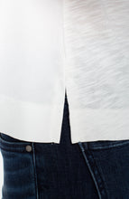 Close-up of side slit detail on whipped cream sleeveless V-neck woven-to-knit tank by liverpool over dark denim jeans.