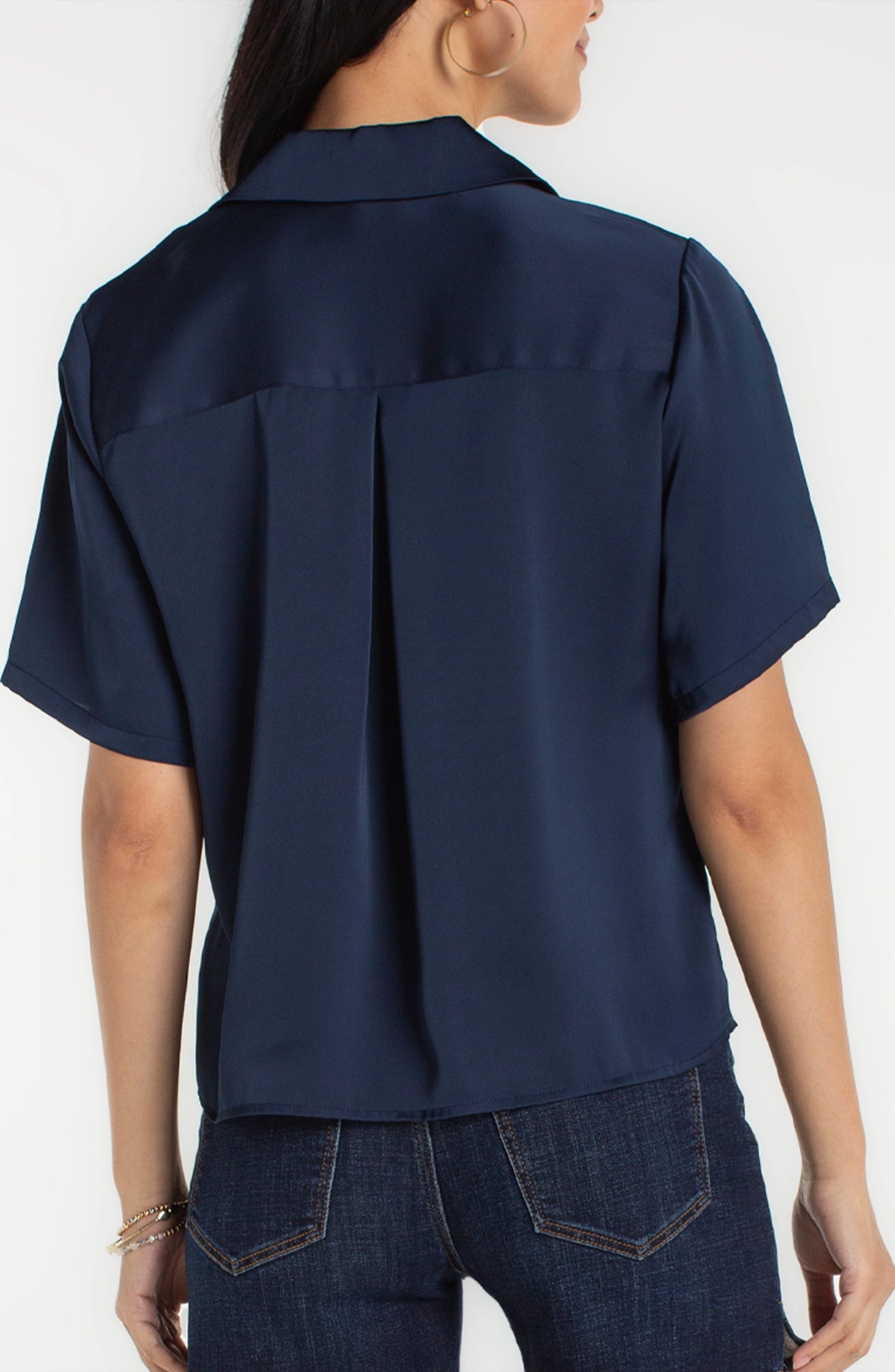Back view of a woman wearing a Dark Navy Short Sleeve Camp Collar Woven Blouse by liverpool paired with jeans