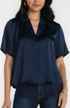 Woman wearing dark navy short sleeve camp collar woven blouse by liverpool paired with dark jeans