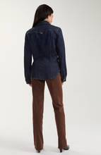 Woman wearing a dark denim Triple Crown Western Slim Shirt by liverpool, paired with brown pants, shown from the back.