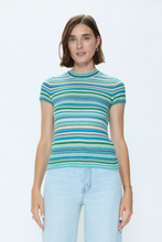Woman wearing a pistola Blue Green Selene top with cool blue and green horizontal stripes paired with light denim jeans