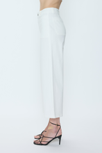 Side view of model wearing white Le Blanc Zooey pants by pistola paired with black strappy heels