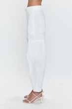 Side view of pistola White Sabrina pants in crisp white with tailored fit and patch pocket details worn with heels