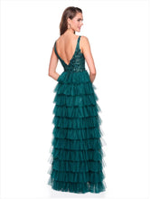 Model wearing Dave & Johnny Prom Dress Style 12635W in emerald green with tiered ruffle skirt and deep V back