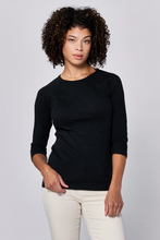 Woman wearing a black Sonoma Tee by Dear John with 3/4 sleeves and a relaxed crew neckline standing against a gray background