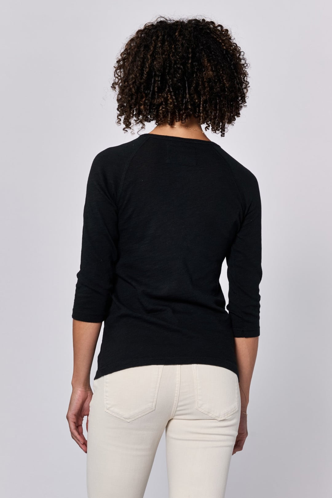 Back view of a person wearing a black Sonoma Tee by Dear John with 3/4 sleeves and relaxed fit styling