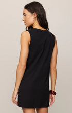 Woman facing away wearing sleeveless black Z Supply Solace Mini Dress with simple back in neutral setting