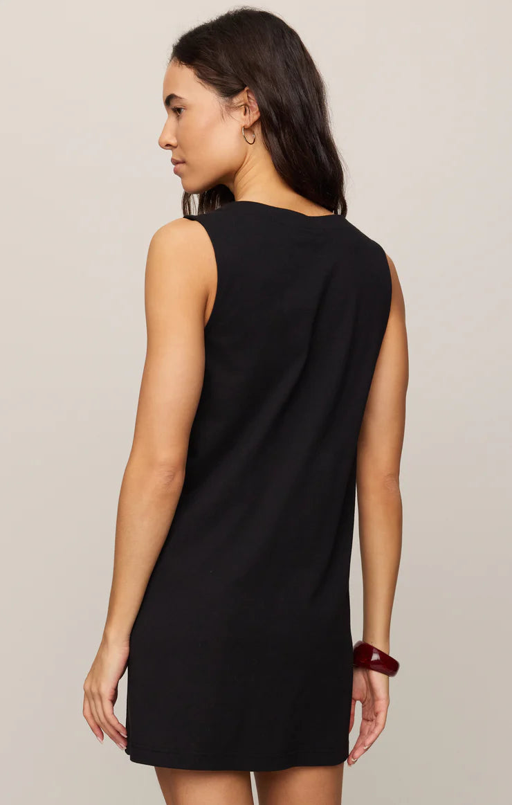 Woman facing away wearing sleeveless black Z Supply Solace Mini Dress with simple back in neutral setting