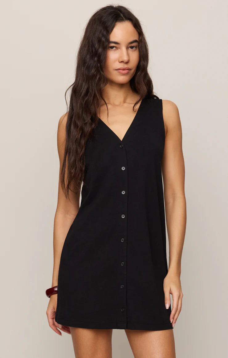 Woman wearing sleeveless black Z Supply Solace Mini Dress with button front and V-neckline in neutral setting