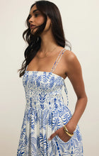 Woman wearing Z Supply Nadine Airy Palm Maxi Dress with blue palm print and adjustable spaghetti straps in neutral setting