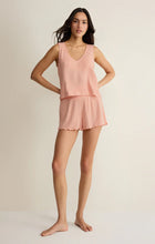 Woman wearing a peach Z Supply Sloane V-Neck Rib Tank paired with matching ribbed shorts in a relaxed pose