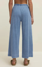 Back view of a woman wearing Z Supply Scout Jersey Denim Pant in soft blue with a wide leg and elastic waistband