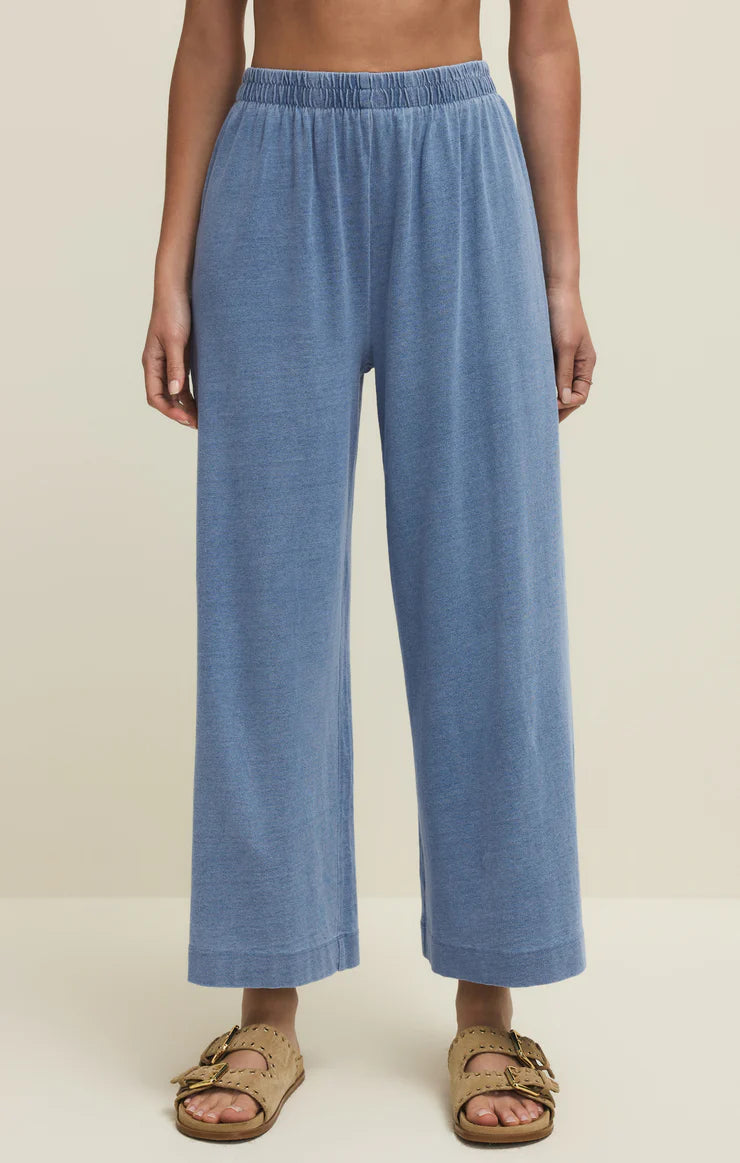 Woman wearing Z Supply Scout Jersey Denim Pant in soft blue with elastic waistband and relaxed wide leg silhouette