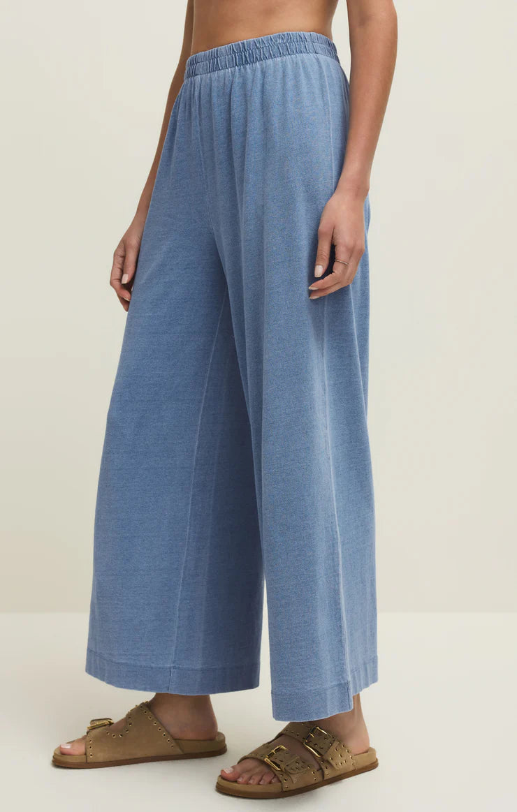 Z Supply Scout Jersey Denim Pant in soft blue with wide leg, elastic waistband, styled with brown slide sandals