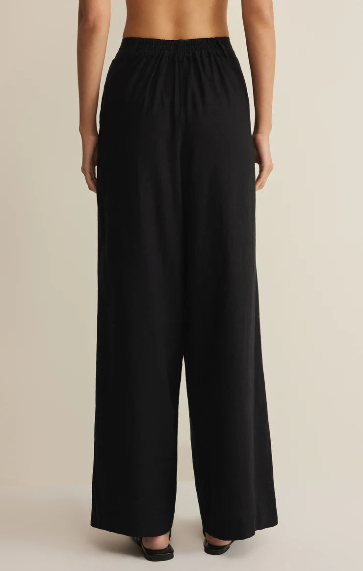 Back view of a model wearing black Z Supply Overlook Linen Pant with a relaxed fit and elastic waist.