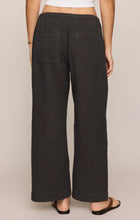 Back view of a person wearing black Z Supply Kit Twill Carpenter Pant with two square back pockets and elastic waistband