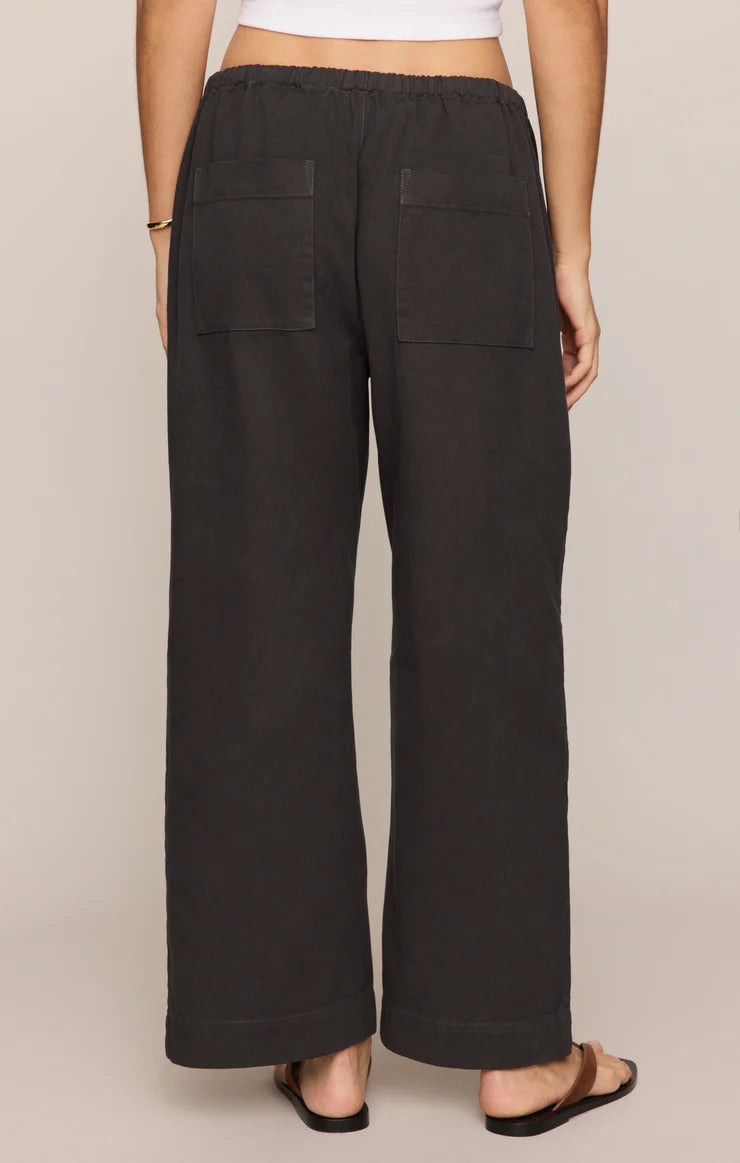 Back view of a person wearing black Z Supply Kit Twill Carpenter Pant with two square back pockets and elastic waistband