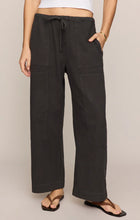 Close-up of a model wearing black Z Supply Kit Twill Carpenter Pant with wide legs and front patch pockets.