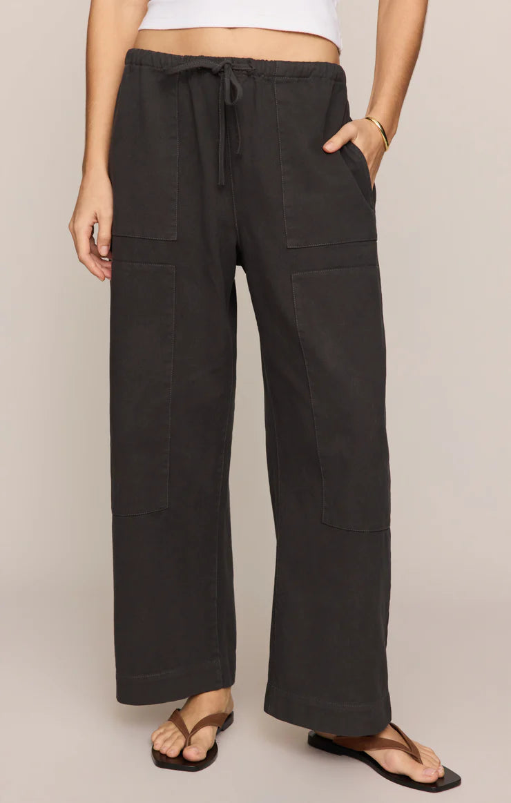 Close-up of a model wearing black Z Supply Kit Twill Carpenter Pant with wide legs and front patch pockets.