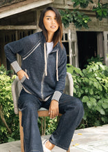 Denim Cardigan in dark denim worn with matching pants by a seated model outdoors