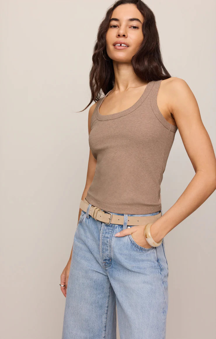 Woman wearing a brown Z Supply Rowe Rib Scoop Tank paired with light blue jeans and a beige belt against a neutral background