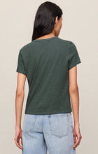 Woman wearing the back view of the Emerald Cove Junie Slub Tee Shirt by z supply in green with light-wash jeans