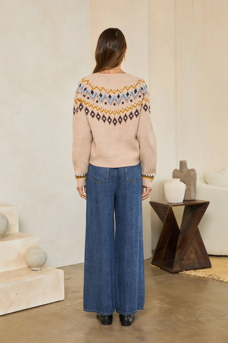 Neutral Mood Sweater by skies are blue shown from the back with a patterned yoke and wide leg jeans