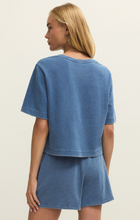 Back view of a woman wearing Calypso Blue Indigo Curran Knit Denim Sweatshirt by z supply in soft indigo blue tone