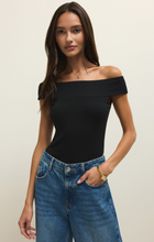 Model wearing a sleek Black Second Skin Off Shoulder Top by z supply paired with casual blue jeans against neutral background