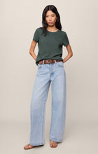 Woman wearing emerald green Emerald Cove Junie Slub Tee Shirt by z supply with light blue jeans and sandals
