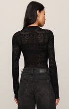 Rear view of woman wearing Black Avery Sweater Top by z supply with intricate knit design and black denim jeans