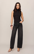 Woman wearing Black Silva High Neck Tank from z supply paired with wide-leg black jeans and heels.