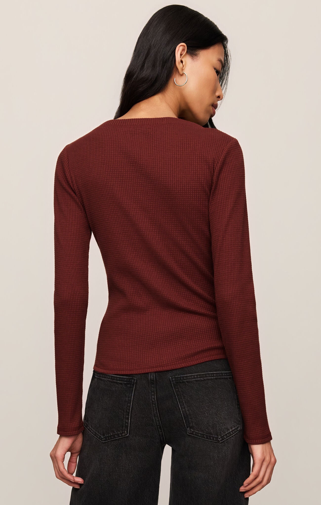 Back view of a woman wearing a maroon Velvet Rouge Albany Waffle Button Up Top by z supply with black jeans.