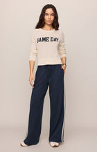 Woman wearing a Sandstone Varsity Stand in Sweater by z supply in light beige with 