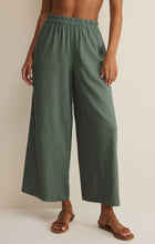 Front view of a woman wearing olive green Z Supply Scout Linen Pant with elastic waistband and wide-leg design