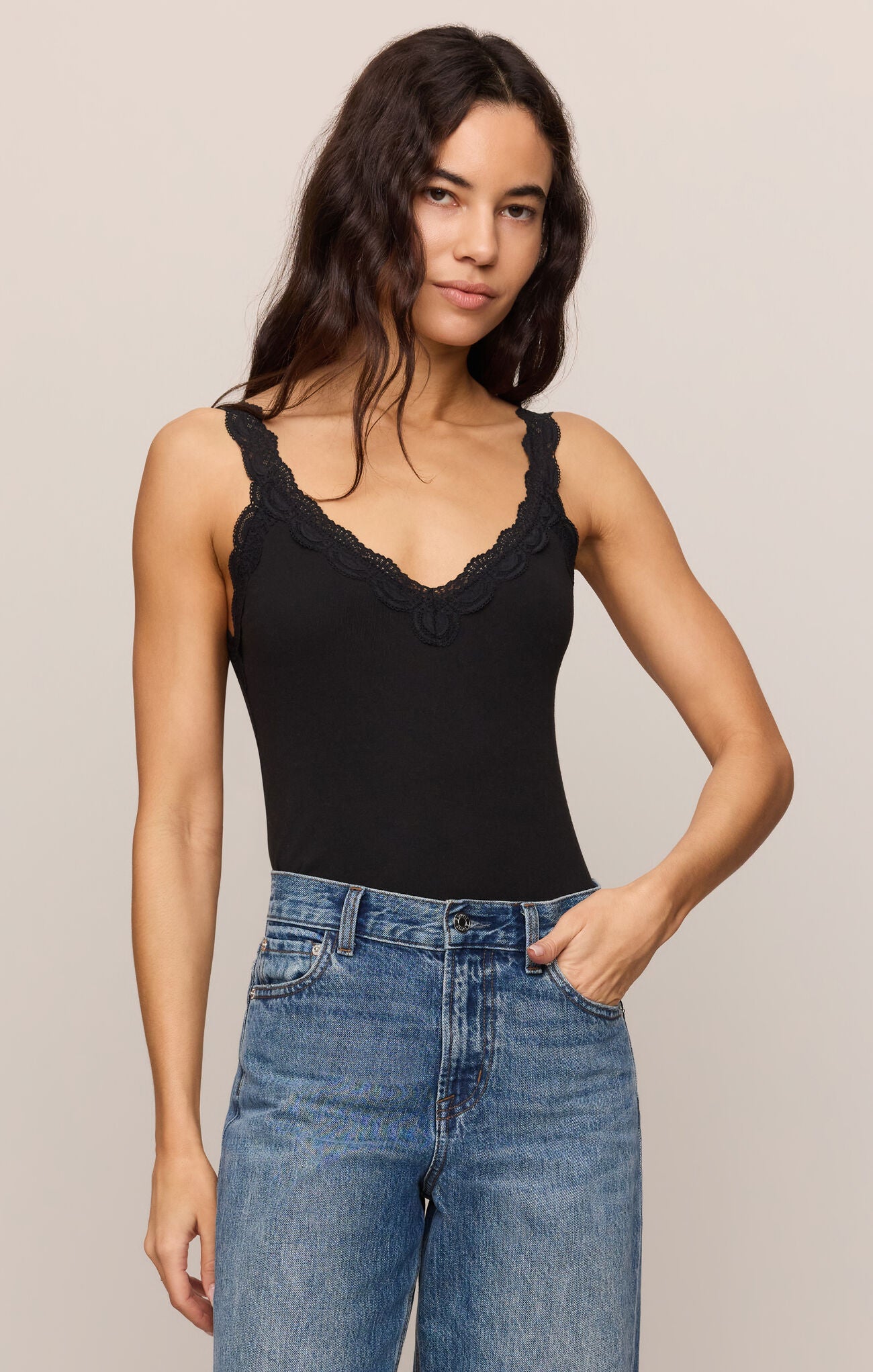 Woman wearing a Black Eve Lace Tank with scalloped lace straps and neckline by z supply, paired with blue jeans