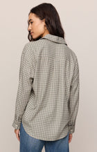 Woman wearing an Emerald Cove River Plaid Button Up by z supply, shown from the back in muted green plaid pattern.
