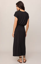 Woman wearing Black Anika Midi Dress by z supply, shown from back with short sleeves and relaxed fit silhouette