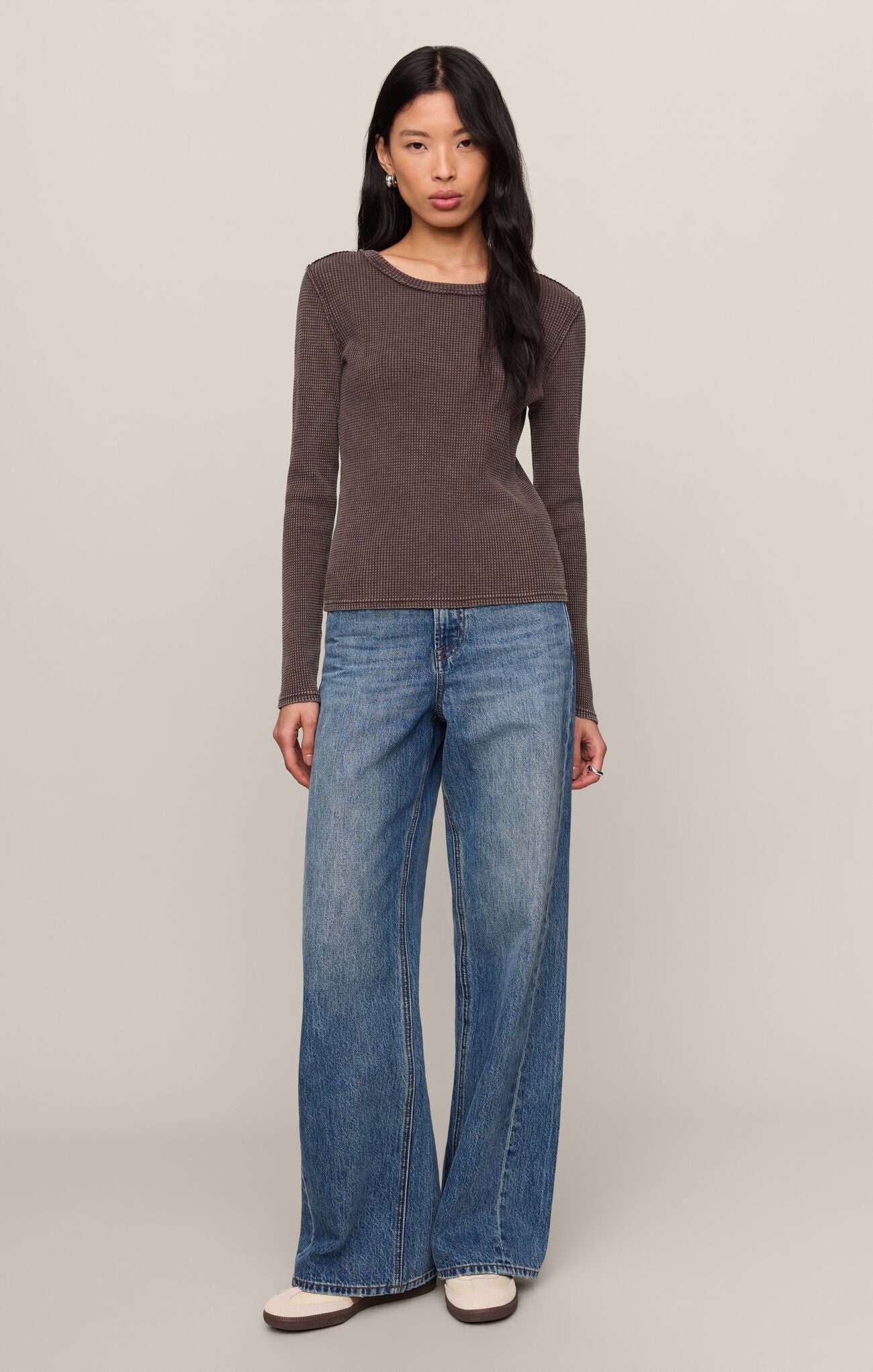 Woman wearing a Dark Chocolate Arlet Mini Thermal Top by z supply with long sleeves and crew neck, paired with wide-leg jeans.