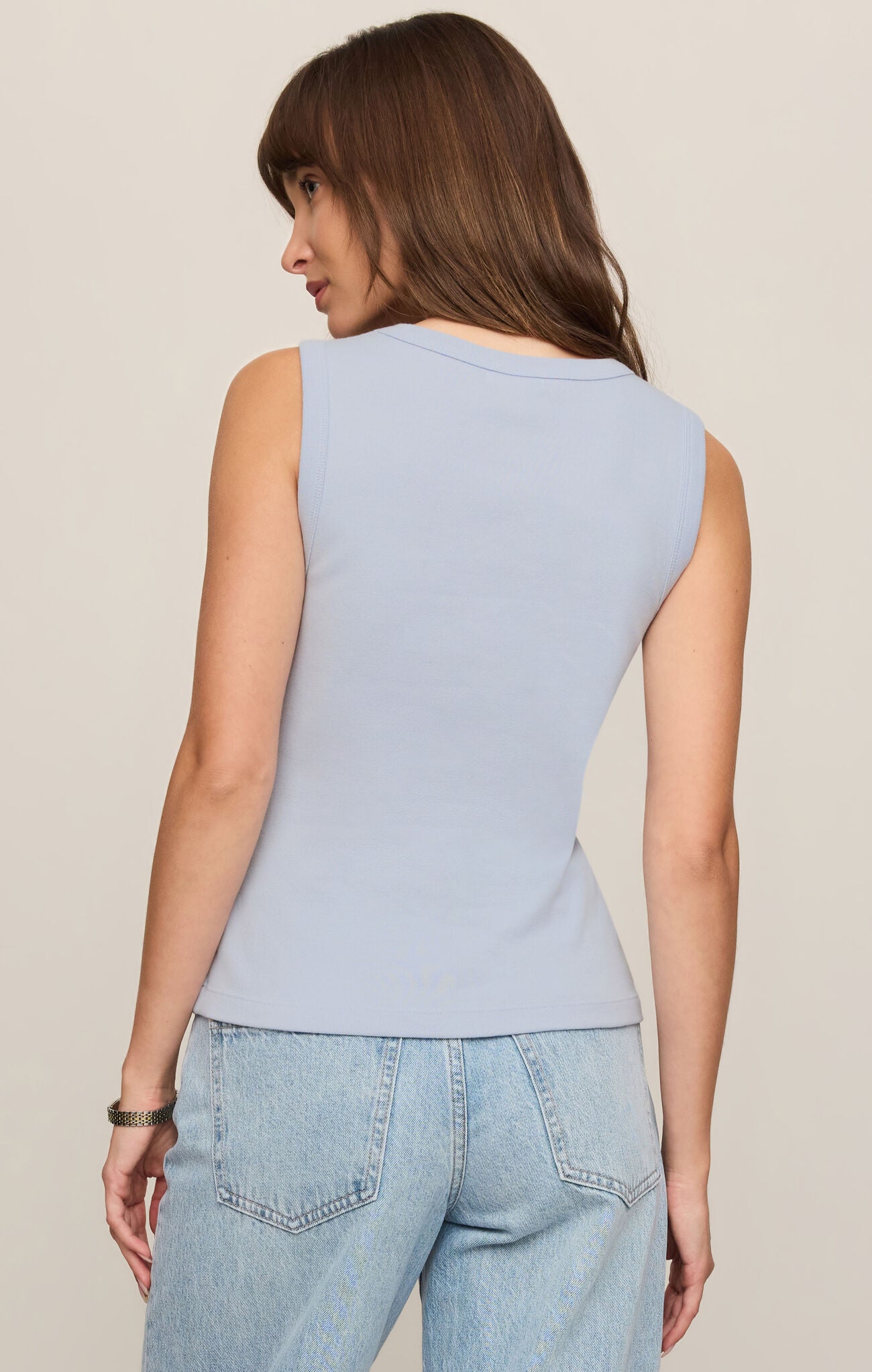 Woman wearing light blue Skyline Ellie V Neck Tank by z supply, shown from the back with light denim jeans