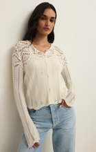 Woman wearing an ivory Cloud Alycia Crochet Sweater by z supply with intricate crochet patterns and button front detail