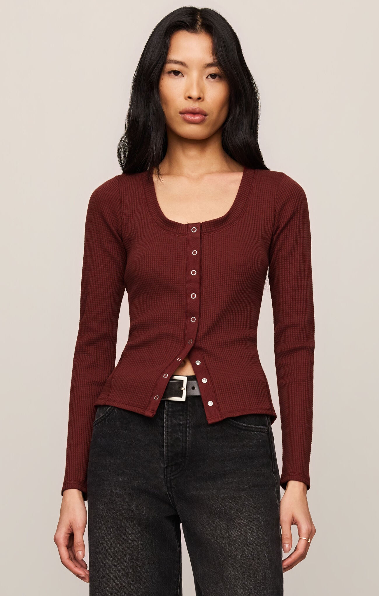 Woman wearing a deep red Velvet Rouge Albany Waffle Button Up Top by z supply with long sleeves and silver buttons.
